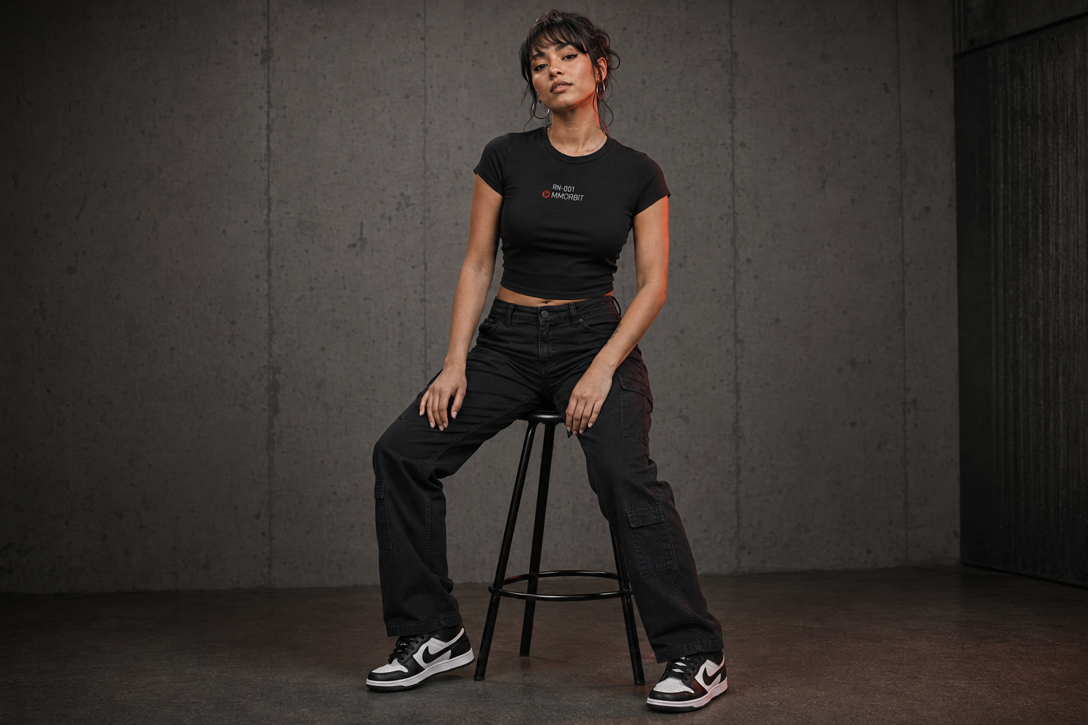 One adult older-teen model wearing the fitted MMORBIT Awakening baby tee in a natural campaign portrait