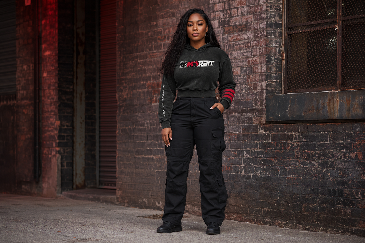One adult woman wearing the feminine cropped MMORBIT Gravity Training hoodie in a relaxed campaign portrait