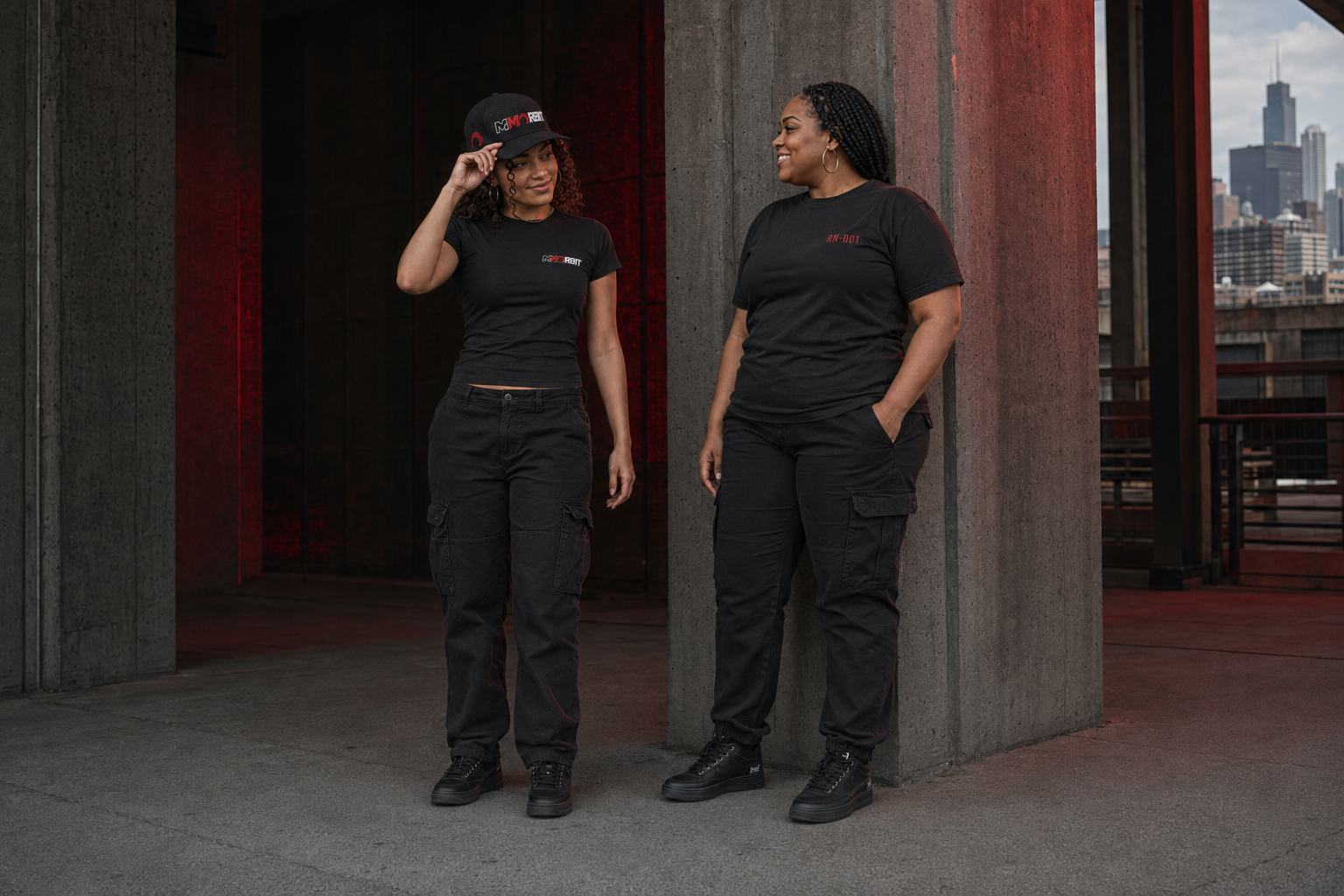 An adult older teen and an adult woman standing naturally together while styling the lower-profile MMORBIT cap