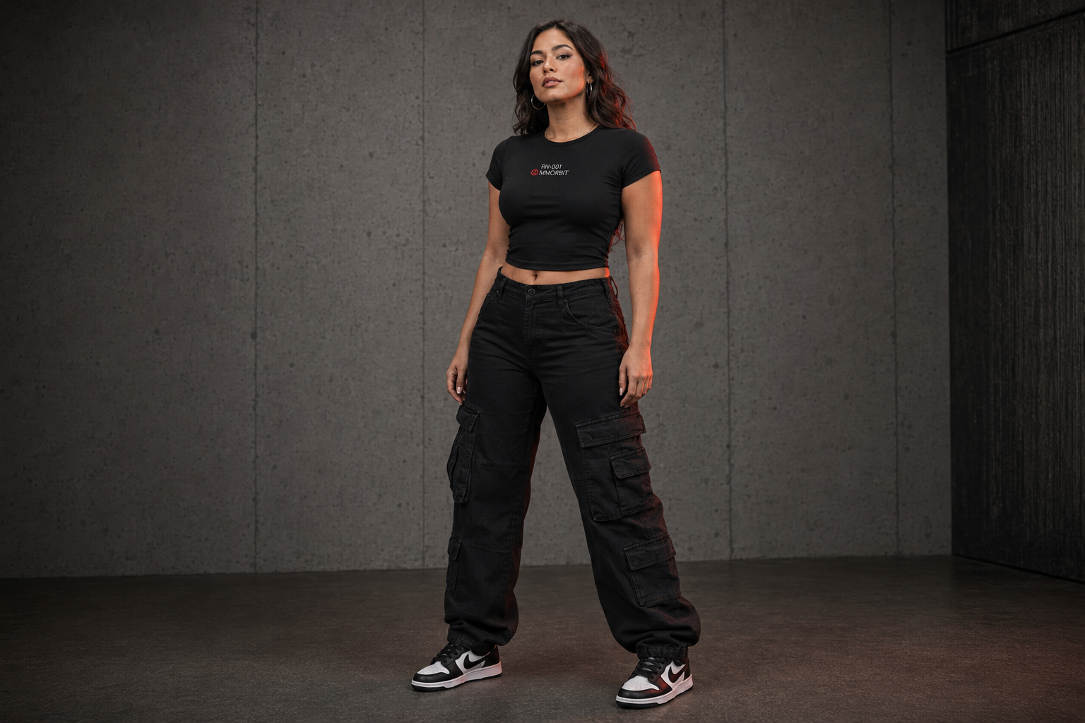 One adult woman showing the close fit and high-hip length of the MMORBIT Awakening baby tee