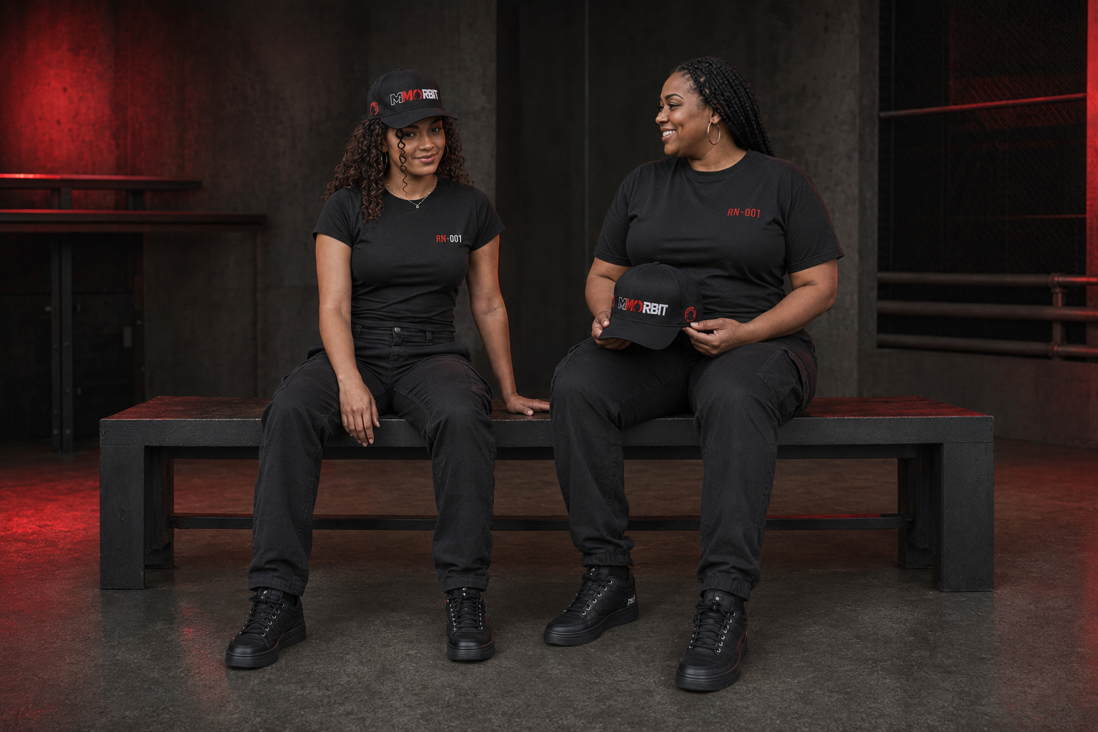 Two adult models seated together while showing the low-profile MMORBIT cap from two angles
